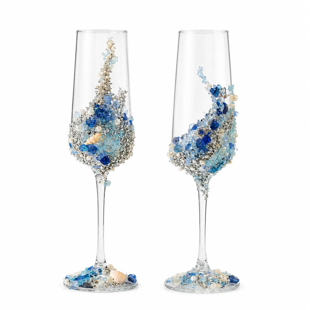Two decorative champagne flutes with blue and gold embellishments on a white background