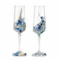 Two decorative champagne flutes with blue and gold embellishments on a white background