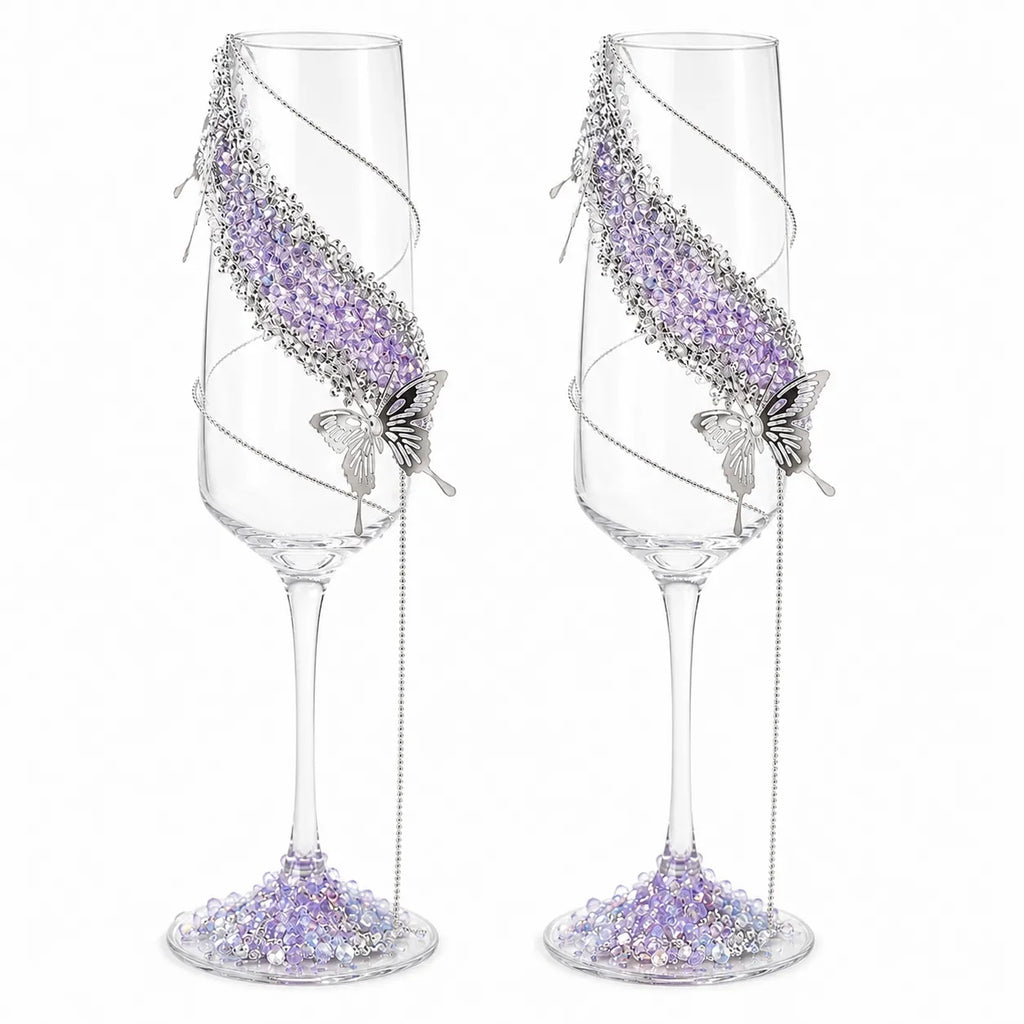Two decorative champagne flutes with purple beadwork and butterfly designs on a white background.
