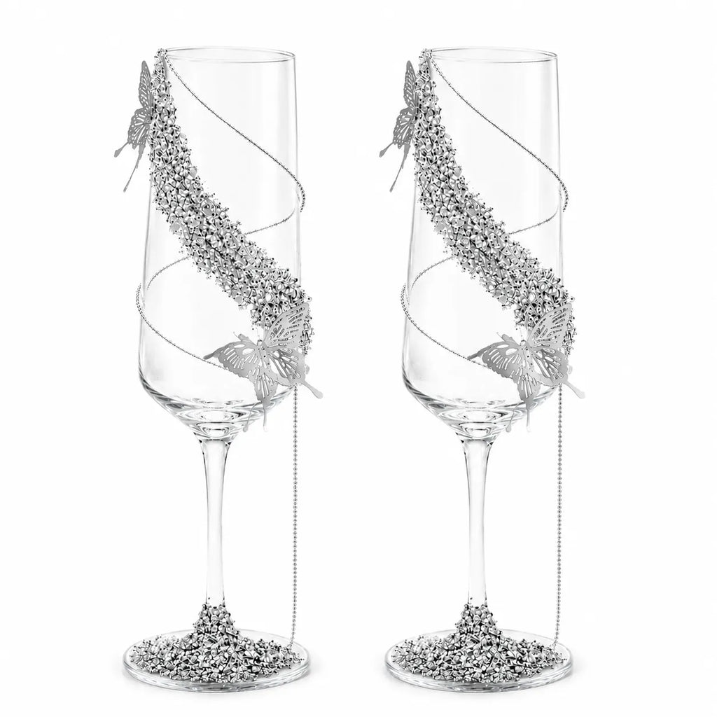 Two decorative champagne flutes with silver embellishments on a white background